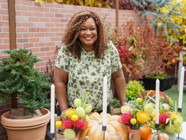 Sunny standing in front of table setting with candles and flowers; wide shot, as seen on Sunny Anderson Thanksgiving.