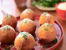 I grew up eating arancini with my dad at a local Italian cafe! I remember how excited he was when he realized we could get them locally, and I instantly fell in love with them and started making them with my mom every year around the holidays. They were huge and always filled with melty mozzarella. Here, I'm using fontina for a bit of nuttiness and I've added prosciutto because, well, I can never have too much prosciutto! These are great for using up leftover risotto and turning it into a fabulous appetizer.