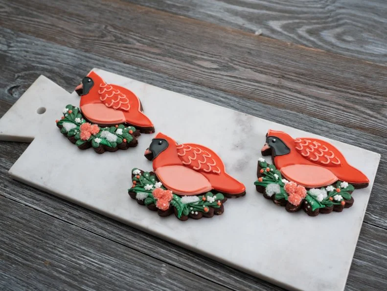 Contestant Mik's Chocolate peppermint mocha cookie with classic royal icing; Puzzle Design: Cardinal bird nestled into a holly nest, as seen on Christmas Cookie Challenge, Season 4.