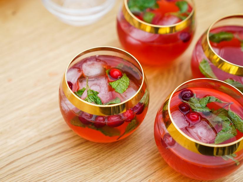 Outdoor island setting; overhead of Cranberry Mojito Pitcher drink; four filled cups, as seen on Sunny Anderson Thanksgiving.