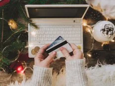 Woman using credit card to shop online, close up