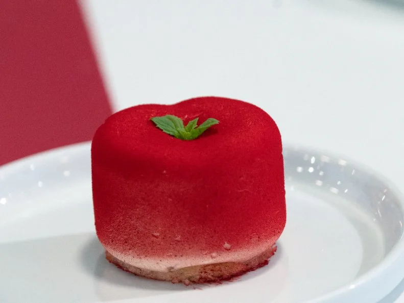 Mini Treat created by Robert Niento.with the following ingredients: Lemon Olive Oil Cake w/ a Vanilla Cheesecake, Mango Jam, Candied Almonds / styled to look like a Cherry with a Mint Stem, as seen on Candyland, Season 1.