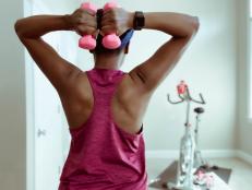 Mid adult black woman enjoys light upper body workout before at-home cycling session