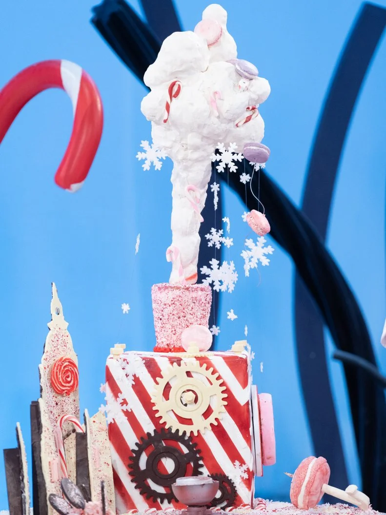 The cake called Cloudblaster 6000 created by contestants Alexis Nicole, Andrew Fuller, Mona Marwaha, Robert Nieto with the following ingredients:.Shredded Coconut (macaron) .Peppermint Bark .Starlight Candies.Mini Candy Canes.Peppermint Nuggets.and Crushed Peppermint, as seen on Candyland, Season 1.