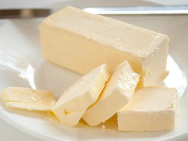 A stick of butter with several small pats cut off.
