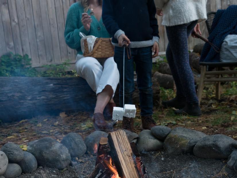 Matyas roasts marshmallows as host Sarah Copeland looks on, as seen on Every Day is Saturday, Season 2.