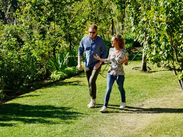 Bobby Flay and Giada De Laurentiis walk through the grounds of Monteverdi in Tuscany, Italy, as seen on Bobby & Giada in Italy, Season 1.