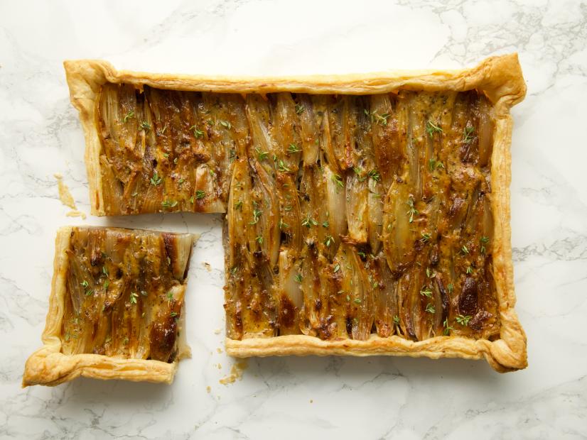 Close-up of Indulgent Shallot Tart with a portion cut off