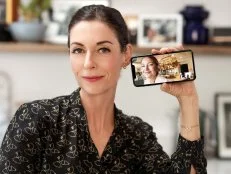 Close-up of Mary McCartney smiling and holding an iphone with Kate Hudson on camera