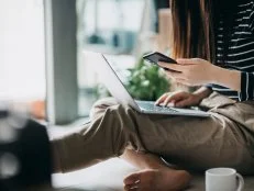 Cropped shot of a young Asian woman in self isolation using laptop and smartphone while working from home
