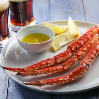Red king crab legs with lemon and beer on a rustic table
