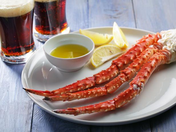 Red king crab legs with lemon and beer on a rustic table