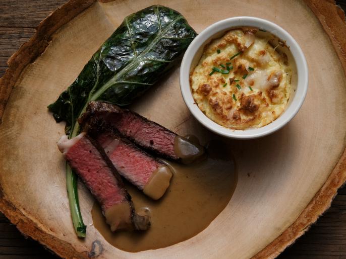 Smoked Rib Eye with White Gravy, Collard Greens and Grits Souffle