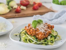 Zoodles bolognese: zucchini noodles with meat or vegan soy meat sauce and parmesan. For low carb, keto, paleo nutrition.