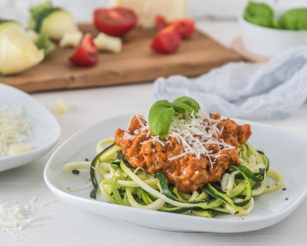 Zoodles bolognese: zucchini noodles with meat or vegan soy meat sauce and parmesan. For low carb, keto, paleo nutrition.