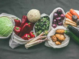 Vegetables in eco friendly food shopping bags at dark background. Zero waste and plastic free lifestyle concept. Top view