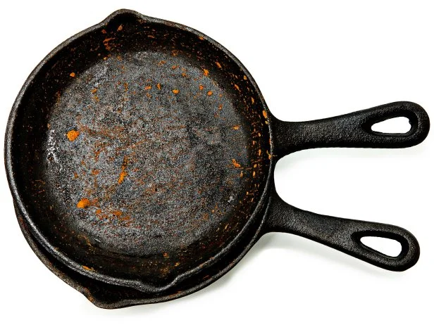 Set of Two Rusty Cast Iron Skillets over white.