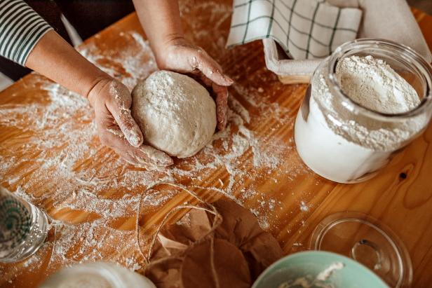 Close-up of woman's hands kneading sourdough on the table