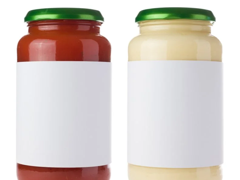 Red and white pasta sauce jars isolated on white with blank labels. Ideal for imposing your own artwork onto.