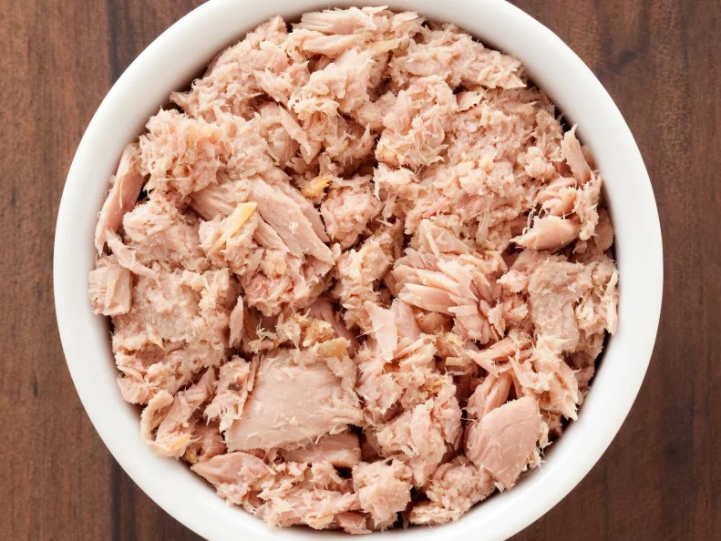Top view of white bowl full of canned tuna