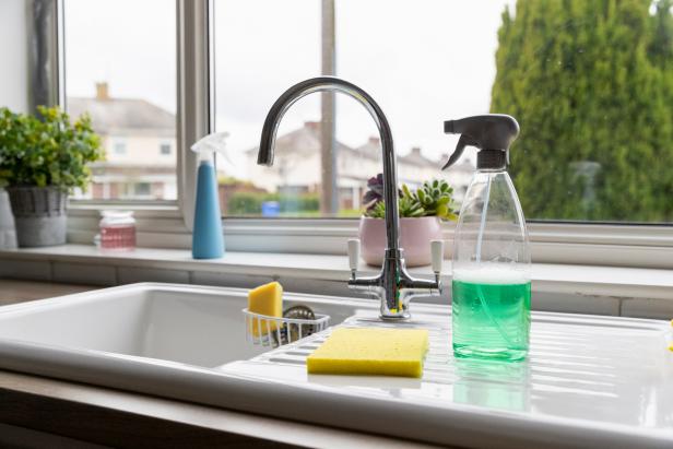 A selection of cleaning products on top of a kitchen sink.