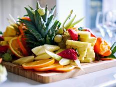 Slicing fruits on a wooden board close-up
