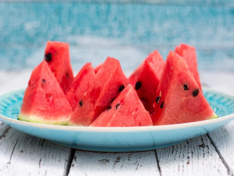 frisch aufgeschnittene Wassermelone, blauer Teller, Holztisch, Studio