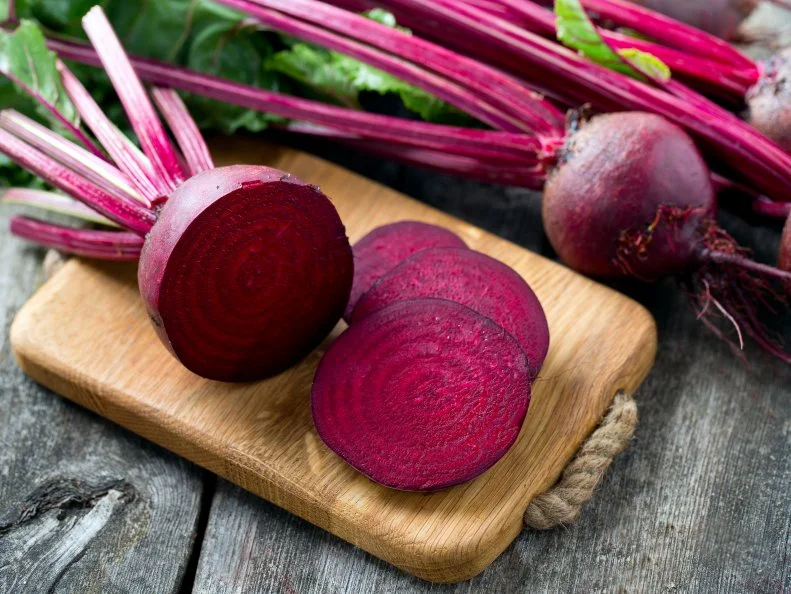 fresh sliced beetroot on wooden surface