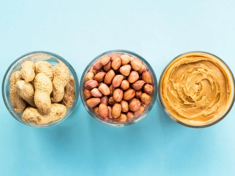 Three jars of peanut in a shell, peeled peas and vegan peanut butter. Cooking Natural Healthy Food Concept. Top view, flat lay