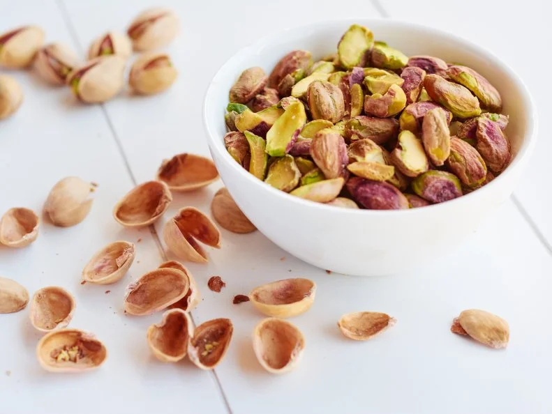 Shelled pistachio nuts in a small bowl.