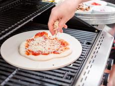Cooking pizza on outdoor gas grill.