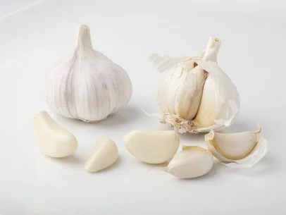 https://food.fnr.sndimg.com/content/dam/images/food/fullset/2021/05/25/head-of-garlic-and-garlic-cloves.jpg.rend.hgtvcom.406.305.85.suffix/1621974634336.webp