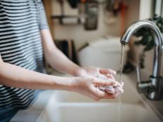 Cropped shot of a woman maintaining hands hygiene and washing hands with soap in the sink