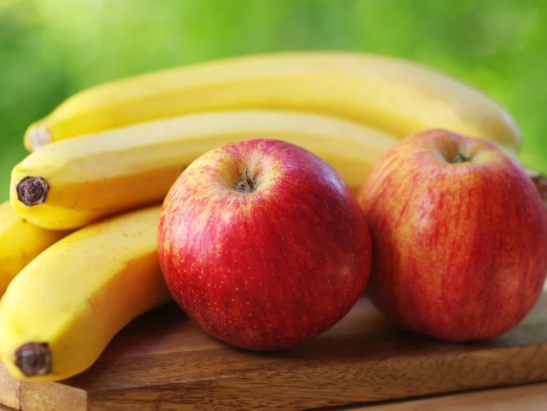 bananas and apples on green background