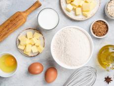 Ingredients for baking on concrete background. Flour butter eggs sugar oil oat flakes and spices on grey background, cooking and baking flat lay composition