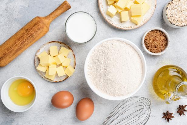 Ingredients for baking on concrete background. Flour butter eggs sugar oil oat flakes and spices on grey background, cooking and baking flat lay composition