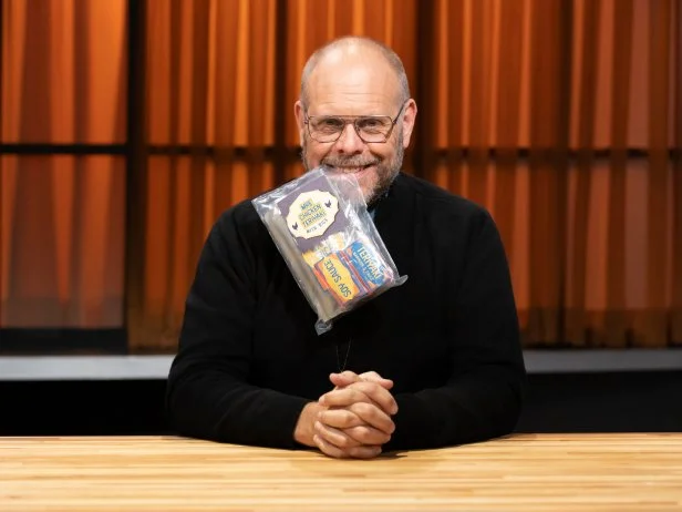 Judge Alton Brown with fan choice round 2 basket ingredient MRE, as seen on Chopped, Season 50, Alton Brown Maniacal Baskets Tournament.