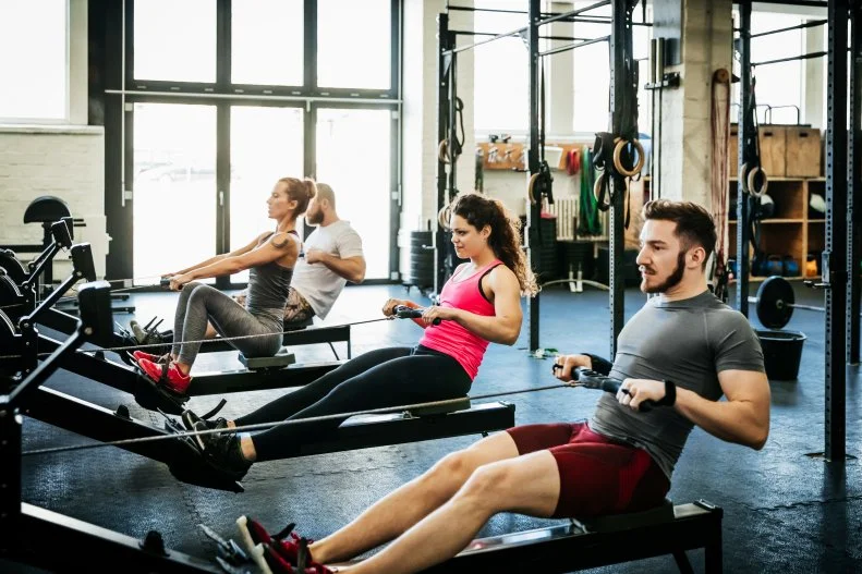 People on Rowing Machines at Fitness Gym