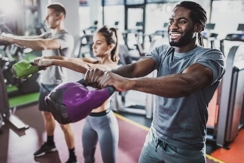 Man Swinging Kettlebell at a Gym