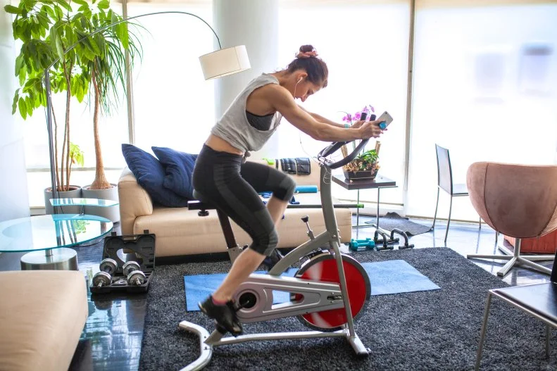 Woman Riding Stationary Bike in Living Room