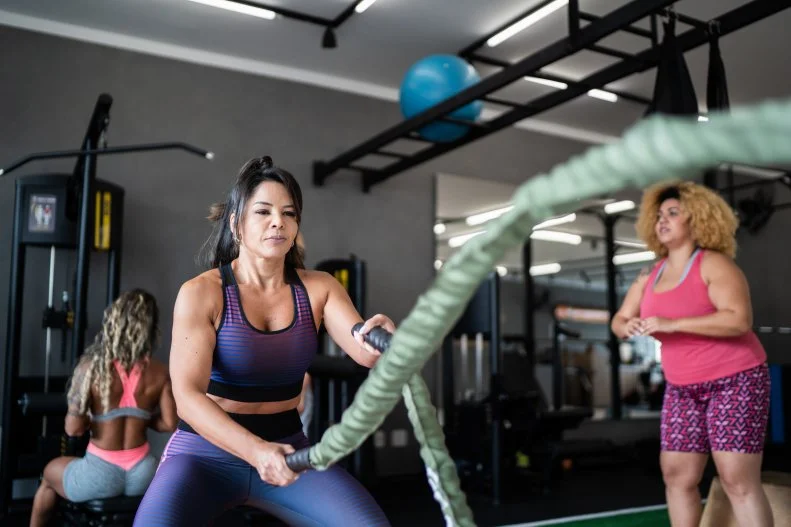 Woman Using Battle Ropes at Fitness Gym