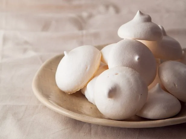 Homemade meringues on ceramic plate and linen fabric