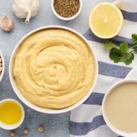 Hummus ingredients for cooking - chickpea, tahini, olive oil and herbs. Middle eastern cuisine. Top view.