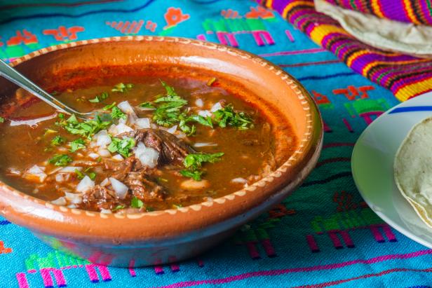 Traditional beef birria stew, Mexican food from Jalisco state. Served with fresh onion, cilantro and corn tortillas. A popular breakfast and hangover cure in much of Mexico
