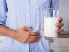 Mid Section View Of A Woman With Stomach Pain Holding Glass Of Milk