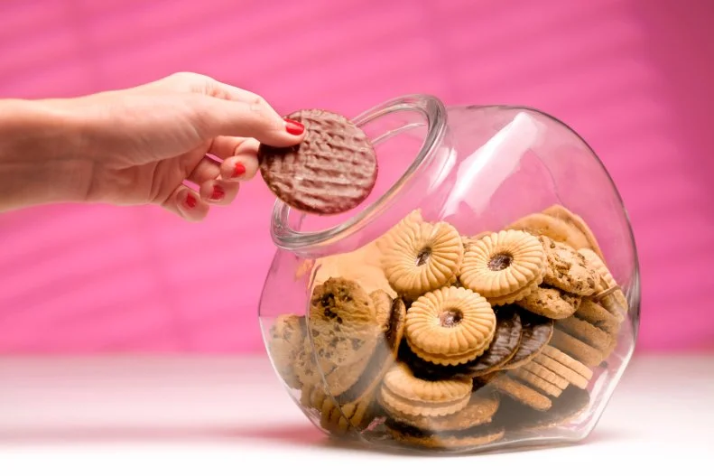 Hand Removing Cookie from Cookie Jar
