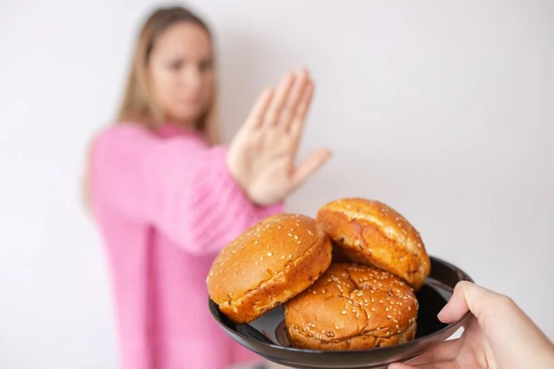 Woman Turning Down Plate of Bread