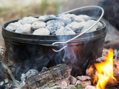 https://food.fnr.sndimg.com/content/dam/images/food/fullset/2021/08/17/black-cast-iron-dutch-oven-campfire-coals.jpg.rend.hgtvcom.406.305.suffix/1629236473683.jpeg