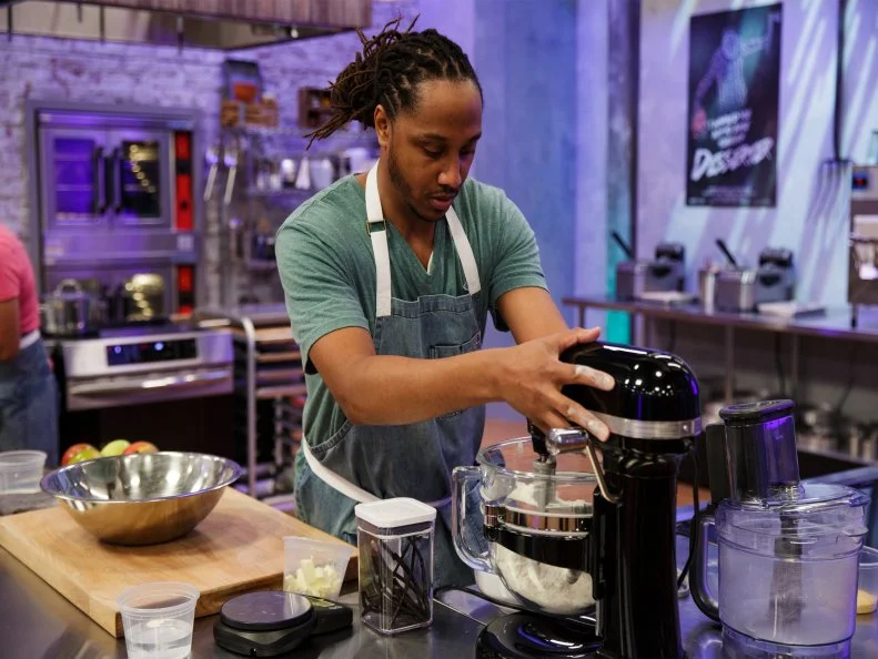 Paul Allicock sets up his mixer, as seen on Halloween Baking Championship, Season 7.