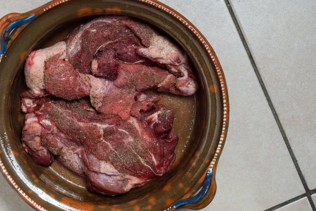 Cooking beef birria stew, Mexican food from Jalisco state. Raw seasoned beef marinating in birria sauce